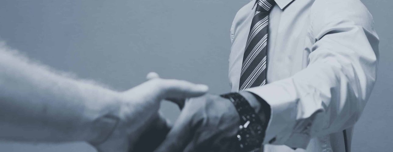 Business concept - Close-up of two confident business people shaking hands during a meeting