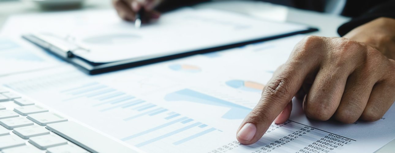 Asian business woman analyzing investment charts on desk. Vintage tone Retro filter effect,soft focus,low light.(selective focus).
